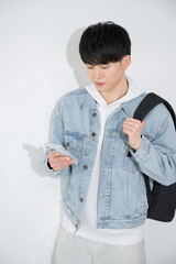 スマホを持つ若い20代の笑顔でタップする男性白背景