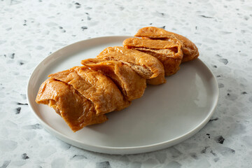 A view of a plate of inari sushi.