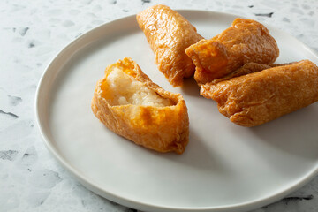 A view of a plate of inari sushi.