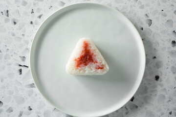 A top down view of soured plum onigiri on a plate.