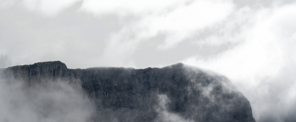 Panorama of blue colored misty mountain with areas of transparent sky

