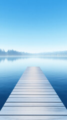 Naklejka premium serene wooden pier extends over calm lake under clear blue sky