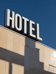 Hotel building exterior with bold signage against a clear blue sky, representing modern travel, tourism, and hospitality industry, ideal for branding, accommodation, and lodging concepts

