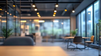 Blurred modern office interior with glass walls and warm lighting. Ideal for showcasing concepts of teamwork, collaboration, and modern workspace design.