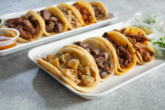 A view of a variety of street tacos on trays.