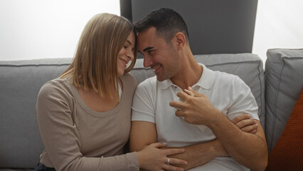 Couple smiling lovingly at each other, sitting in a cozy living room, embodying love and togetherness, with a warm, intimate atmosphere showing their connection.