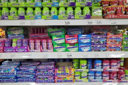 Penang, Malaysia - Feb 2, 2025: A neatly arranged display of Mentos chewy mints and Doublemint gum on a grocery store shelf.