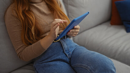 Young woman using tablet indoors in cozy home setting showing hands on device relax on sofa