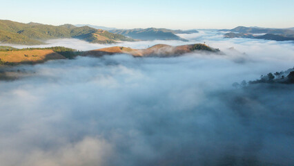 Aerial landscape view of the sea of fog flowing on hills