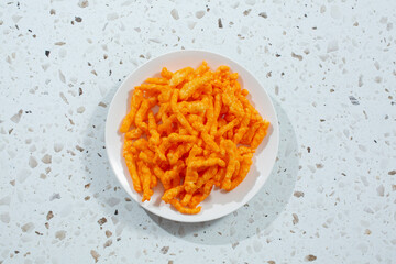 A top down view of a plate of popular cheesy crunchy chips.