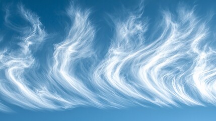 Fototapeta premium Wispy white clouds streak across a vibrant blue sky.