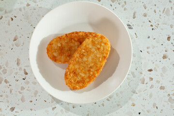 A top down view of two hash brown patties.