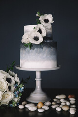 Elegant wedding cake decorated with white flowers and a dark background for a sophisticated celebration © tisaeff
