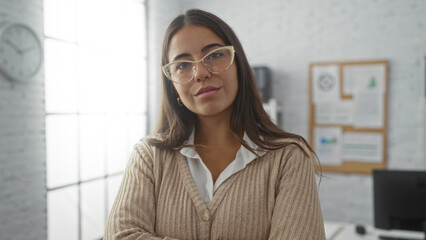 Woman posing confidently in an office setting with glasses, showcasing professional attire and a...