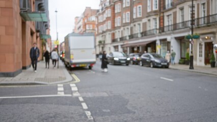 Urban life in a blurred london street scene captures people walking on a winter day with iconic buildings and vehicles in the background.