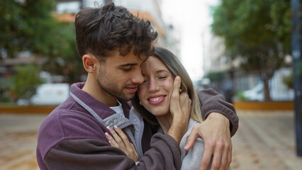 Man and woman embracing lovingly in an urban street showing their relationship under the open skies...