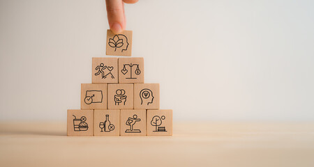 Holistic Wellness Concept. Wooden block with wellness icons, health care ,including mental well-being, fitness, nutrition, sleep, relationships and financial balance. Personal development and balance.