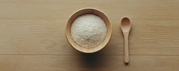 bowl of millet with wooden spoon on wooden surface, showcasing natural textures and colors. This simple yet elegant arrangement highlights wholesome grain