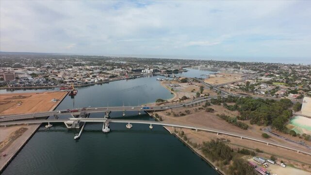 drone view from high showing port adelaide and a bridge with cars running over 4k 50p