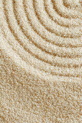 Top view pattern in Japanese Zen Garden with close up lines on sand, meditation and relaxation vibes. Aesthetic minimal sandy background wth copy space, beige monochrome neutral color, vertical
