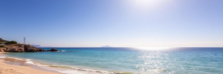Fototapeta premium Beautiful sandy beach with crystal clear turquoise water and majestic mountains in the background, ideal for relaxing vacations and water sports activities, sunny day, blue sky, vacation