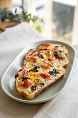 open sandwiches sourdough bread toast for breakfast or brunch with cheese tomato olives.