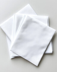Neatly stacked white cotton napkins on light surface, perfect for dining