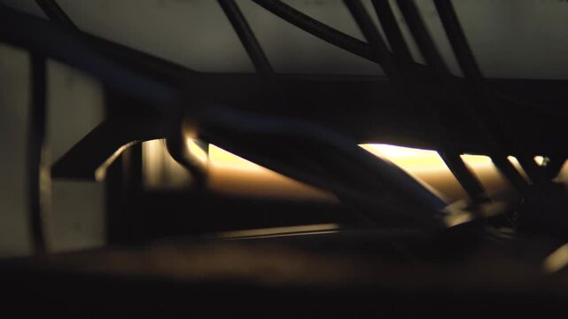 An SDI cable pushes through a small hatch, glowing in cinematic light. Perfect for broadcast, video production, studio setups, and connectivity visuals, capturing a high-tech, behind-the-scenes feel.