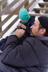 Fototapeta premium A father and son enjoy a fun winter activity outdoors, tubing down a snowy hill. The photo captures their joyful smiles, bonding moments, and the excitement of a thrilling winter sport in a picturesqu