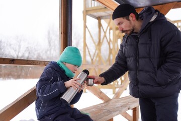 A father and son enjoy a fun winter activity outdoors, tubing down a snowy hill. The photo captures their joyful smiles, bonding moments, and the excitement of a thrilling winter sport