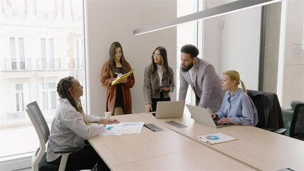 A diverse and talented group of professionals is seen collaborating in a modern office setting, showcasing effective teamwork and fostering innovation within a vibrant and dynamic work environment - Powered by Adobe