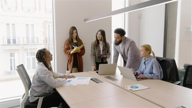 A diverse and talented group of professionals is seen collaborating in a modern office setting, showcasing effective teamwork and fostering innovation within a vibrant and dynamic work environment - Powered by Adobe