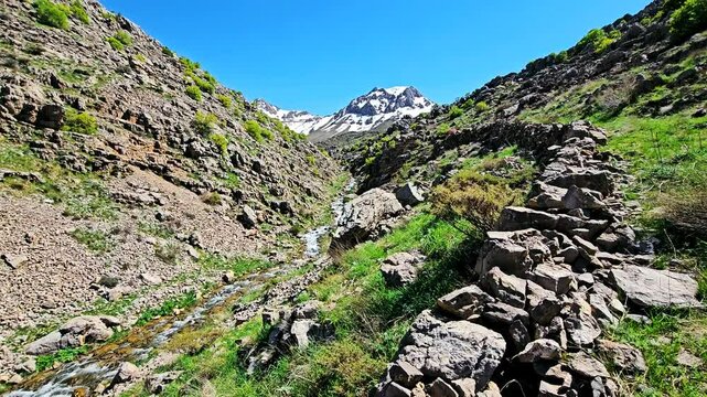 A tranquil mountain stream winds through rocky slopes beneath snow-capped peaks and open skies.
📍Hawraman, Sarvabad - Kurdistan 