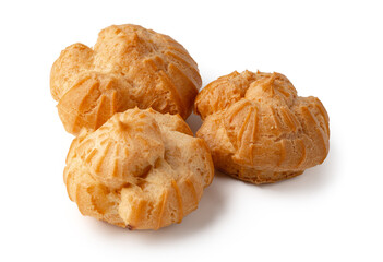 Freshly baked cream puffs displayed on a clean surface in bright indoor lighting