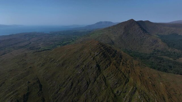 Sugarloaf, Caha Mountains, County Cork, Ireland, September 2024. Drone slowly orbits clockwise, showcasing the raw beauty of the rugged peaks, vibrant greenery, and serene natural landscapes.