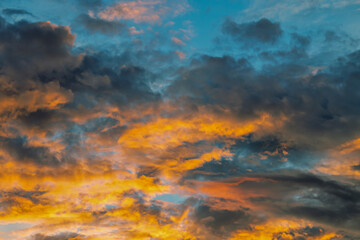 Colorful with yellow, orange and blue in the evening in autumn. A dramatic sky includes a cloud, sunset or sunrise, open space, and a horizon or horizon. For the scene, background and wallpaper.
