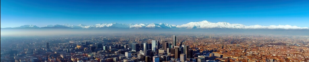 Obraz premium Panoramic View of a Vibrant City Skyline Surrounded by Majestic Snow-Capped Mountains Against a Clear Blue Sky Landscape