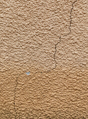 A wall with a crack in it and a small hole in it