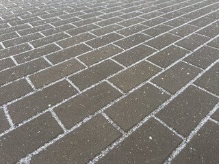 A brick sidewalk with snow on it