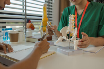 Obraz premium two medical students are discussing treatment guidelines for a patient assigned to them by a senior physician, consultation between two doctors in the office