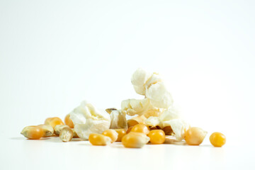 Popcorn. Popped and unpopped popcorn on white background. Ground level horizontal photo. Copy space, blank empty. 
