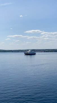 Ferry departing Horten on a sunny summer day with the harbour and Horten city in the background
