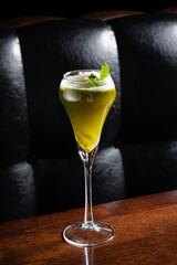 Elegant Green Cocktail Garnished With Fresh Mint Leaves Served in a Stylish Glass Against a Dark, Rustic Background, Evoking a Sense of Sophistication and Indulgence