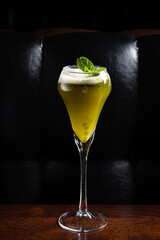 Refreshing Green Cocktail With Mint Garnish Served in an Elegant Glass on a Wooden Table Against a Dark Background