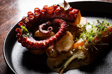 Deliciously Plated Grilled Octopus Served With Vibrant Vegetables and Delicate Garnishes in a...