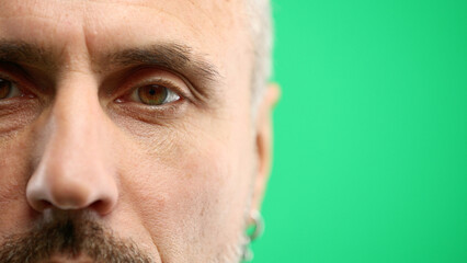 Obraz premium Man's eyes, close-up, on a green background