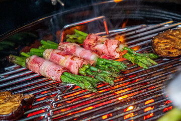 Deliciously Smoky Asparagus Wrapped in Savory Bacon Sizzling on a Grill During a Sunny Afternoon Barbecue Gathering
