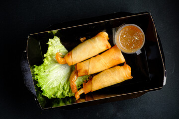 Crispy Spring Rolls With Shrimp Served Alongside a Tangy Dipping Sauce on a Dark Background