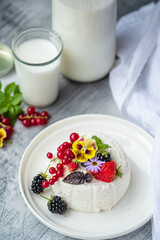 Delightful Dessert Creation Featuring Fresh Berries and Edible Flowers on a Rustic Table Setting in a Cozy Kitchen Atmosphere