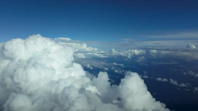 An immersive pilolt&rsquo;s perspective FPV POV flying through a blue sky with some cottony cumulus clouds over the Meditrerranean Sea. 4K. Hyperlapse.